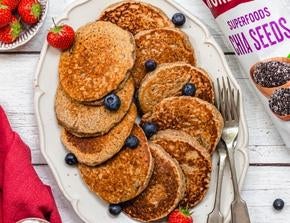 A platter of vegan pancakes, with a sprinkling of blueberries and strawberries