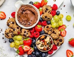 Sharing board with fruit, trail mix cookies, and chocolate hummus