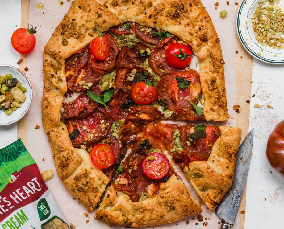 Tomato Pesto Galette on a serving board next to a pack of Nature's Heart Crunch