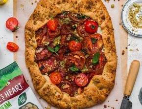 Tomato Galette on a serving board next to a pack of Nature's Heart Crunch